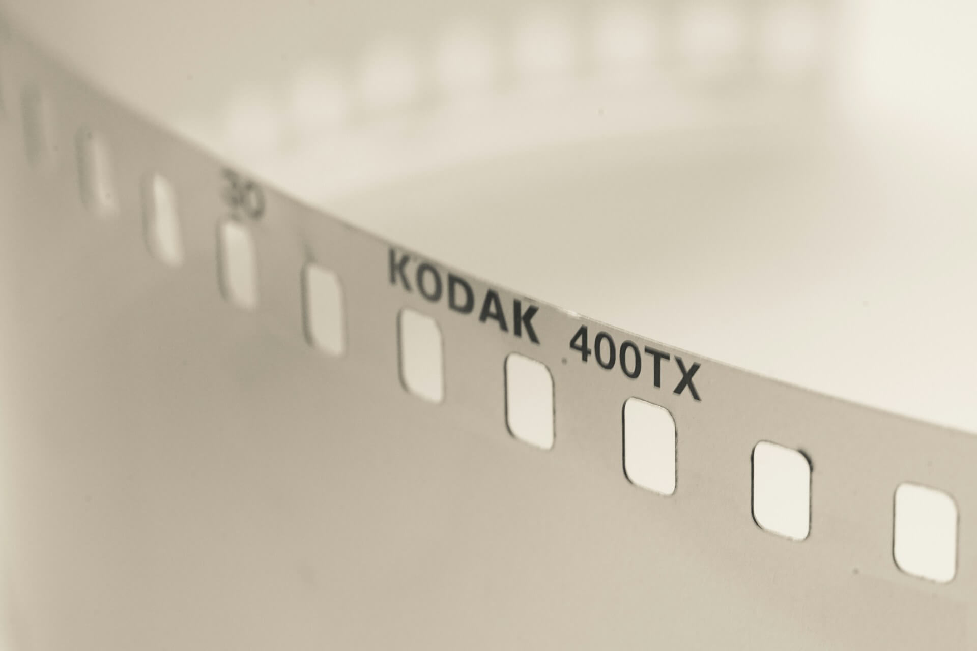 Közelkép egy fekete-fehér Kodak 400TX 35 mm-es filmnegatív széléről és a perforációs lyukakról.